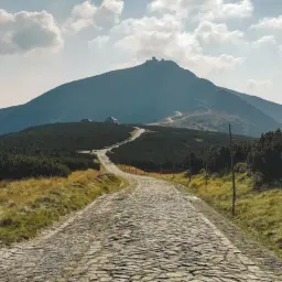 Kamienna droga wije się ku górze Śnieżka, zapraszając na wędrówkę.