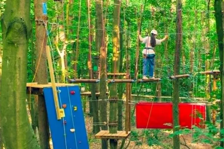 Dziewczynka na ściance wspinaczkowej i na trasie w parku linowym Sopot.